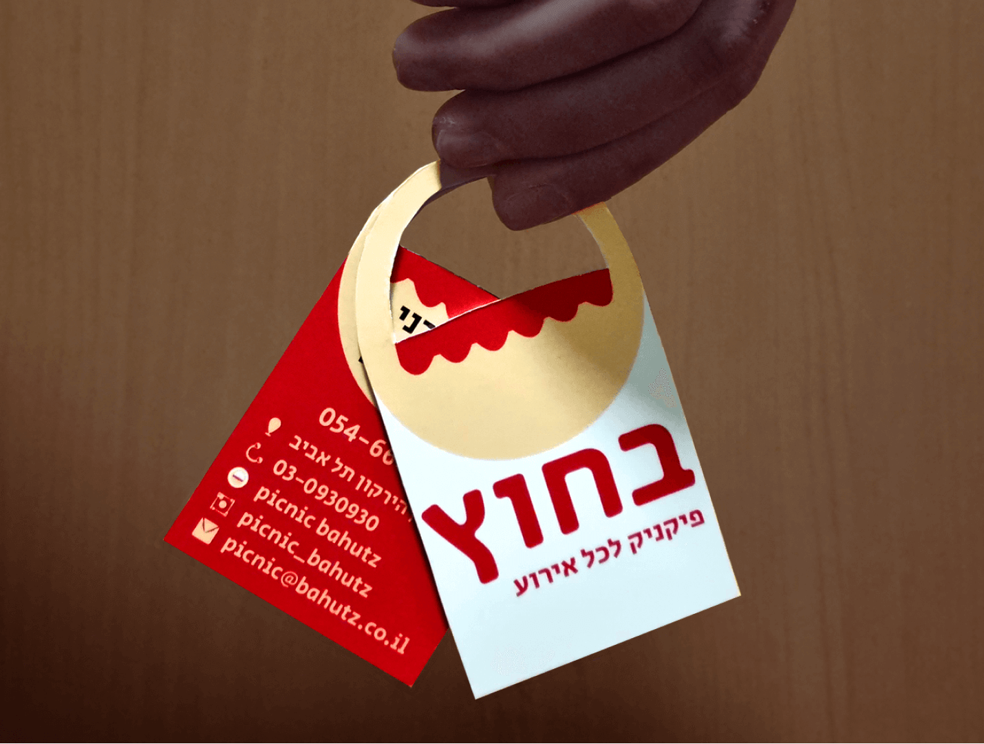 כרטיס ביקור בצורת סלסלה עם לוגו המותג בצד אחד ופרטים בצד שני