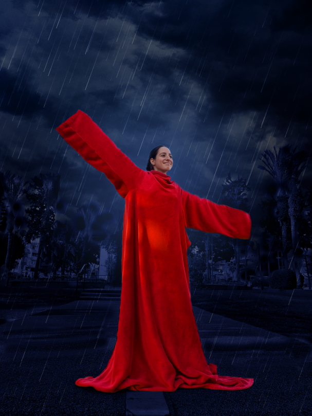 פוסטר רחוב ובפוסטר דוגמנית עומדת ברחוב ביום גשום ולא נרטבת. הדוגמנית עם כירבולית אדומה